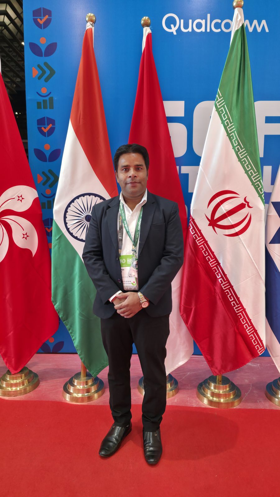 Portrait at the IMC flag line, with the Indian flag behind.