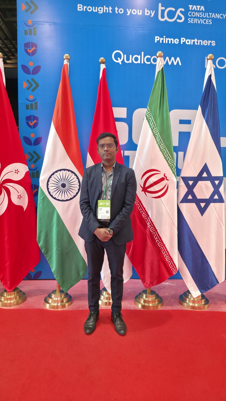 Team member at the IMC 2026 flag wall.