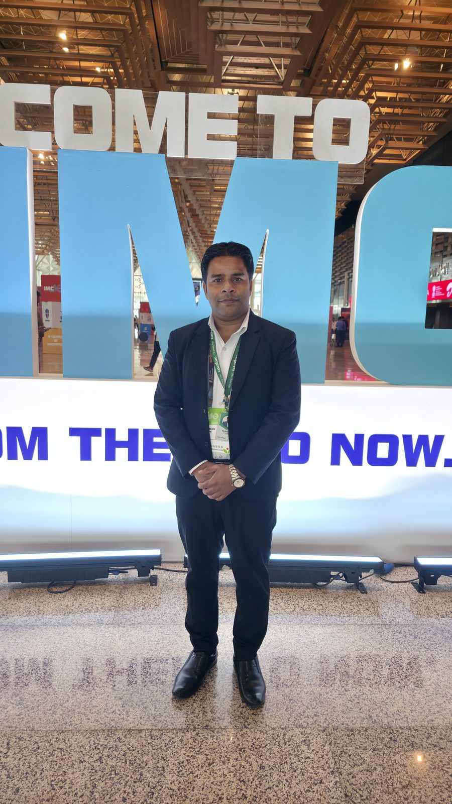 Team member at the Welcome to IMC sign.