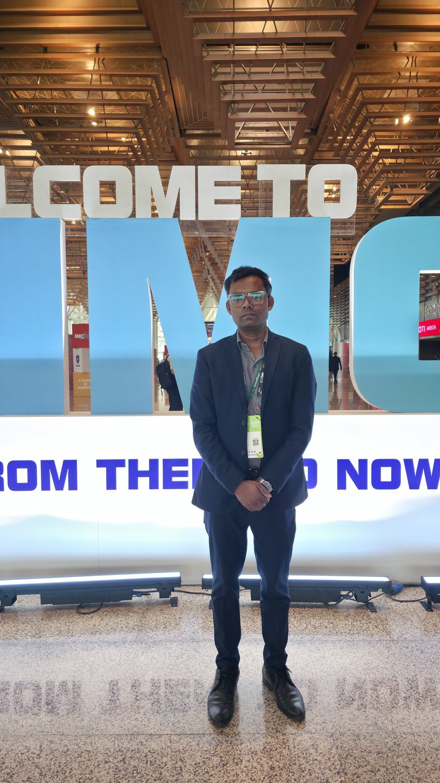 Team member standing at the IMC welcome sign.
