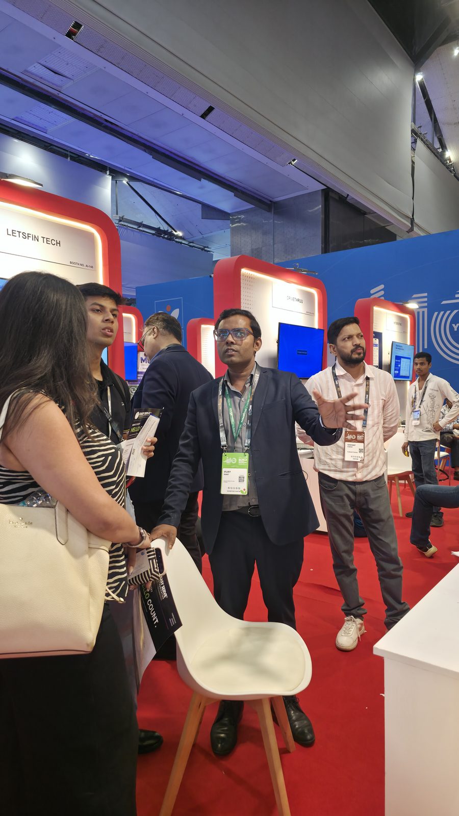 Visitors standing at the booth display.